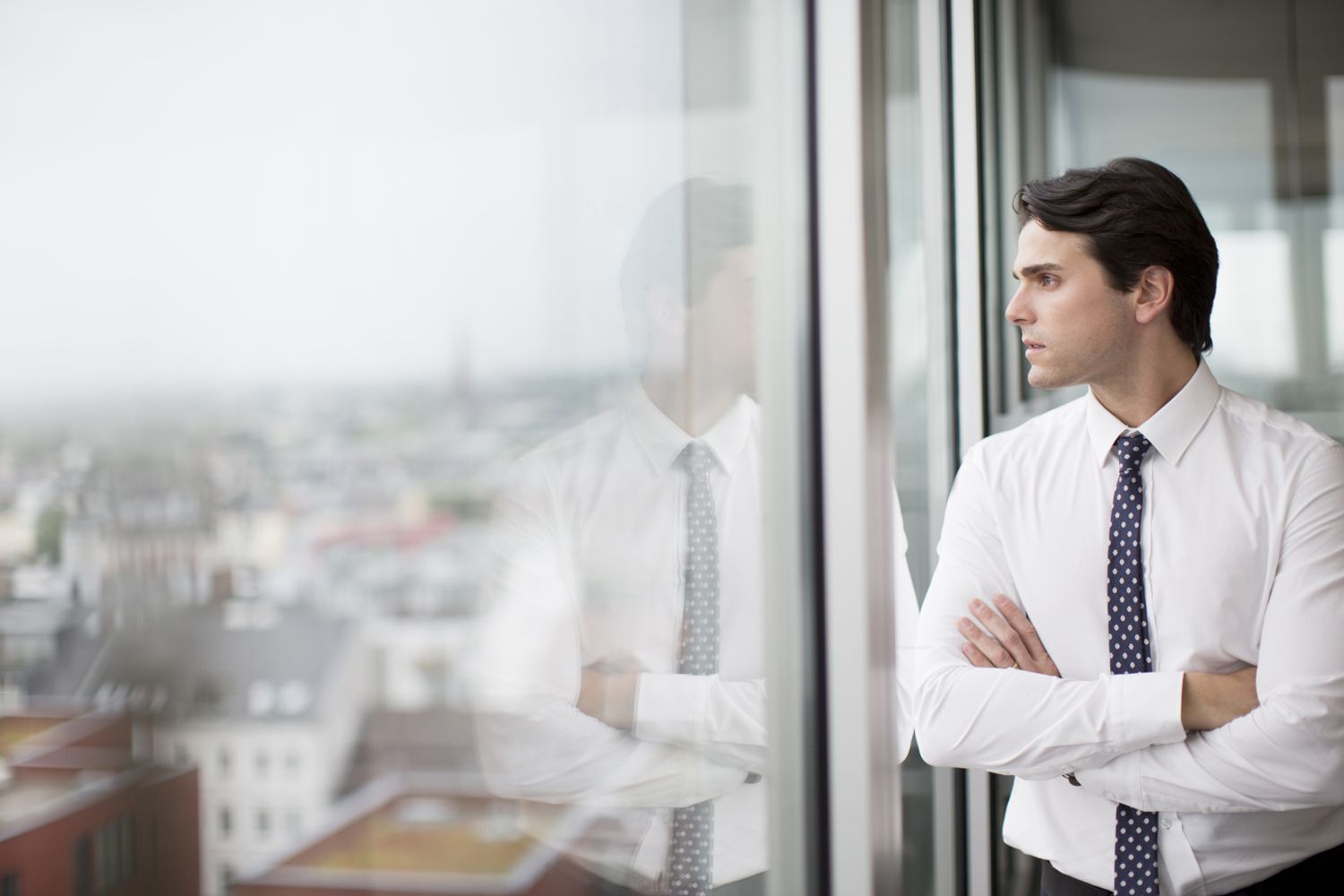 Businessman looking out office window