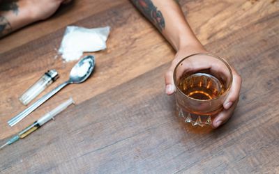 坚硬药物和酒精顶上的射击在木桌上。成瘾概念