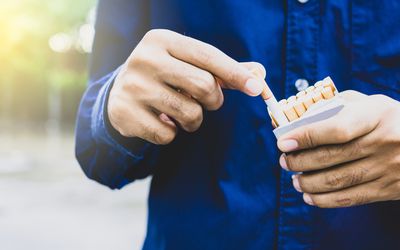 关闭采取从包装的男性手一根香烟