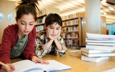 研究在学校项目的男孩和女孩在图书馆里