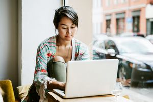 woman working on laptop in cafe window