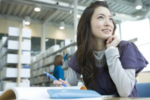 微笑的年轻女子在图书馆学习