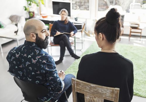 Couple talking to woman taking notes