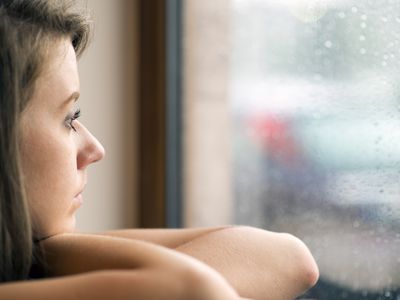 Portrait of the woman looking through the window