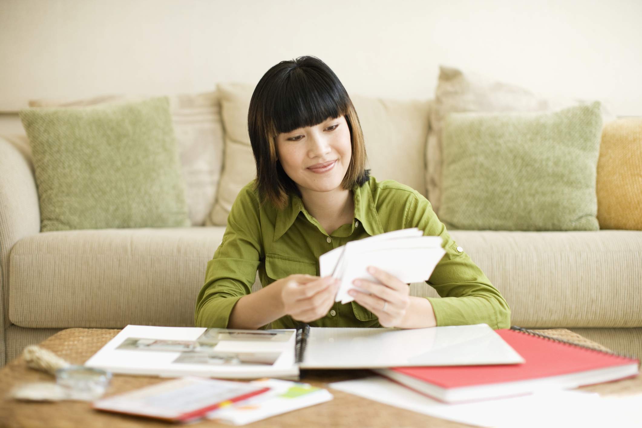 看照片剪贴的妇女在咖啡桌上