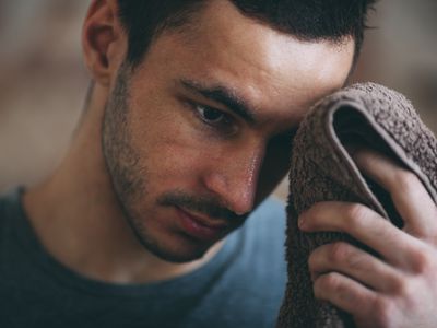 运动的男人在体育馆擦额头上的汗