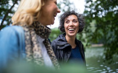 快乐成熟的女人在森林里看着朋友