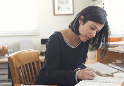 woman writing at desk