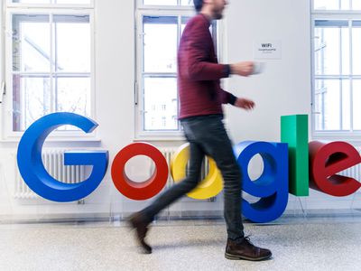 一名男子走在谷歌标志前