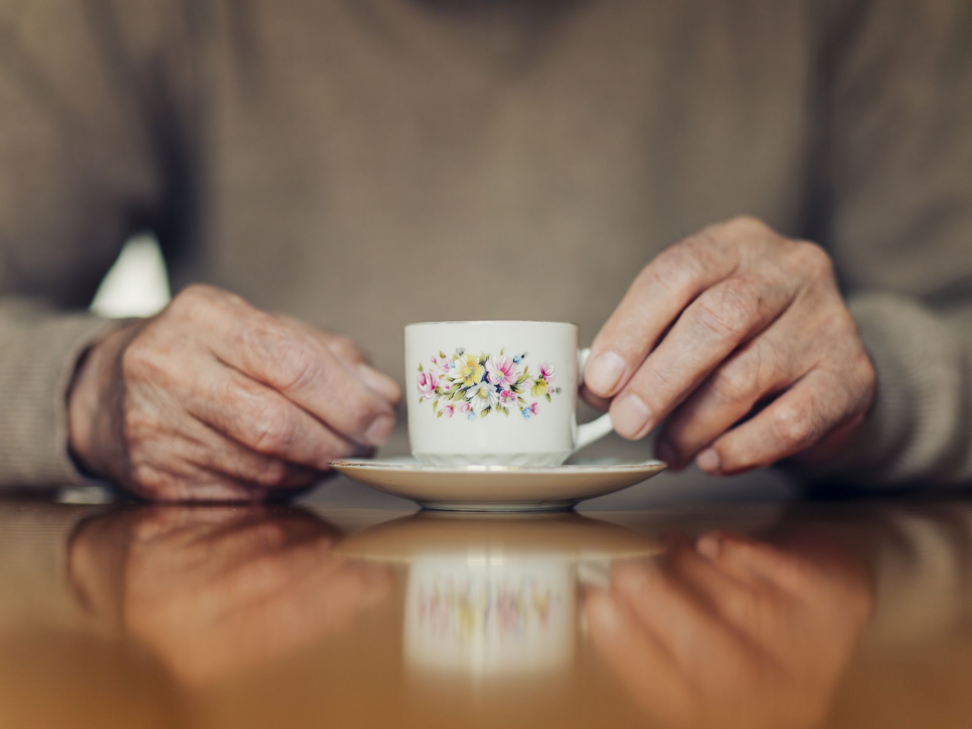 的老人的手特写一个小茶杯