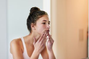 迷人的少女看着镜子中的自己