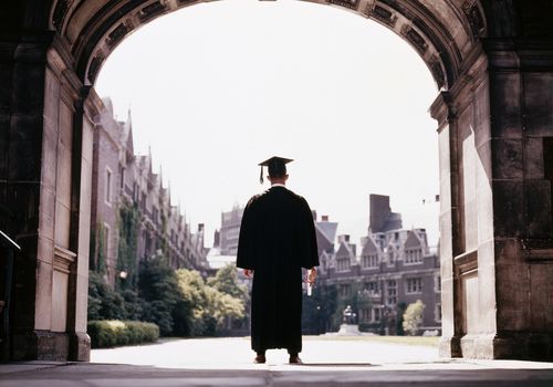 Graduate standing under an arch