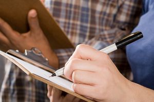 People filling out paperwork on clipboards