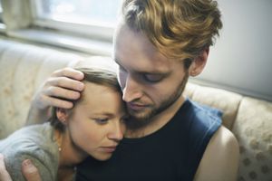 年轻人在沙发上拥抱严肃的女人