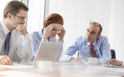 Serious boss talking to businesswoman in conference room