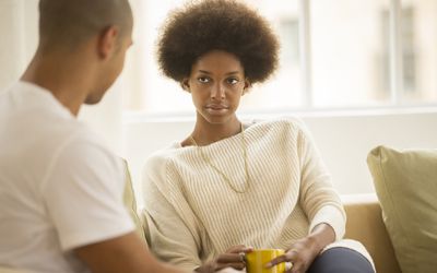 Couple drinking coffee on a sofa