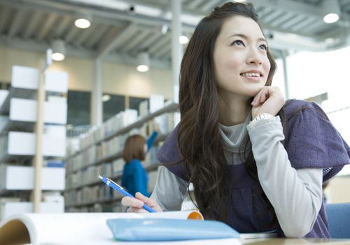 微笑的年轻女子在图书馆学习