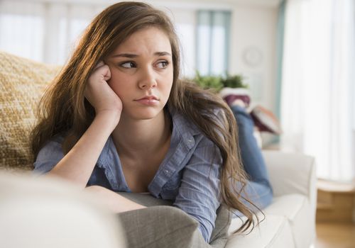 Sad girl laying on a couch