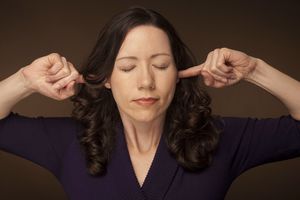 手指插在耳朵里的女人