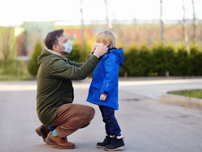 Dad putting a mask on his son