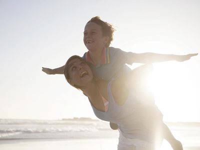 海滩的妇女carying男孩