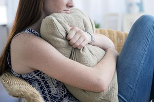 十几岁的女孩（14-15）坐在扶手椅上的伤心