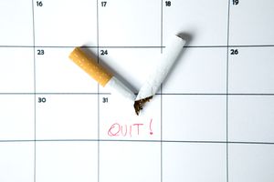 香烟在日历上啪的一声抽成两半，上面写着“戒烟！”上面写着。