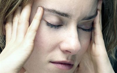 年轻女子头痛，扶着太阳穴