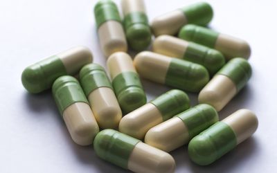 Cream and green capsules on a table