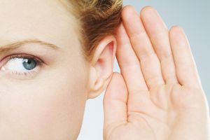 woman listening with her hand up to ear