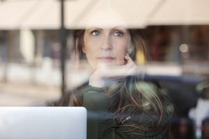 一个女人躲在窗户后面向外看