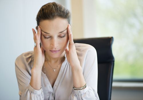 Close-up of a businesswoman suffering from a headache in an office