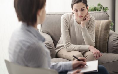 年轻的女病人在办公室与她的治疗师谈论心理健康和心理疗法的概念万博手机客户端