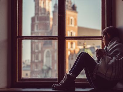 woman looking out the window drinking tea