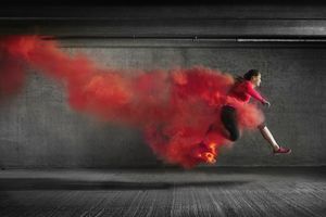 跳跃通过烟的女运动员