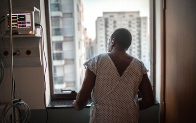 Senior patient looking through window at hospital