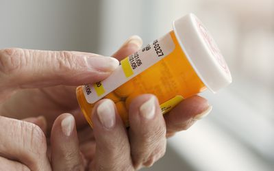 拿着药瓶的妇女的手