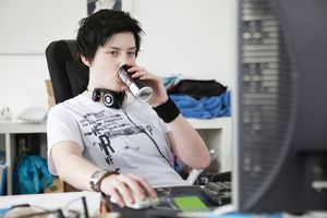 由计算机女人喝能量饮料