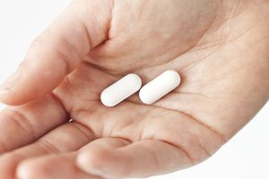 女子抱着特写手的白色药丸，