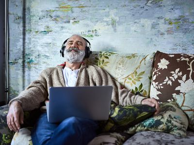 一个男人坐在沙发上，戴着耳机放松