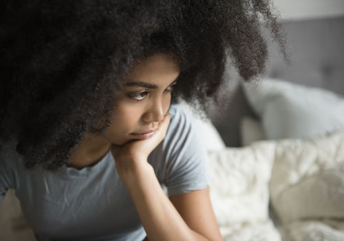 Woman looking depressed in bed