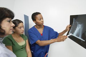 显示青少年和母亲X射线的医生