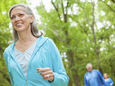 走在公园的成熟微笑的妇女