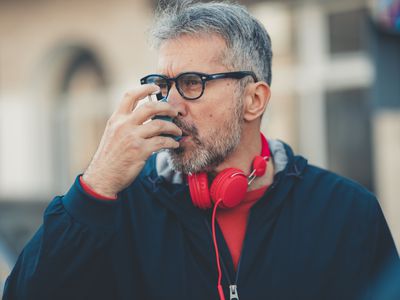 使用哮喘吸入器的人的男人