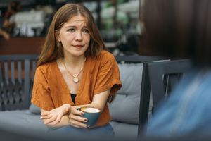 关切的年轻女子在咖啡店与朋友交谈