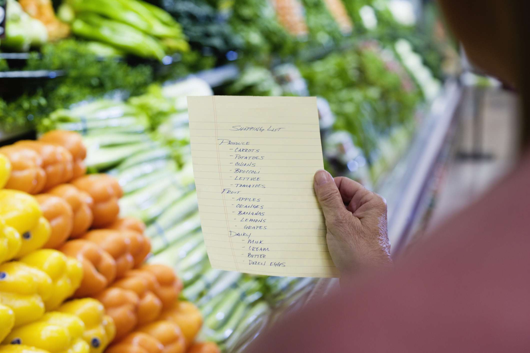 带着购物清单的女人站在农产品过道里