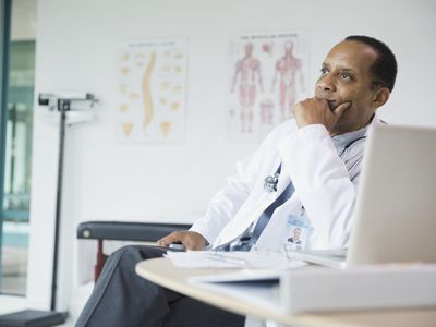 体贴的男医生坐在医院的办公桌前