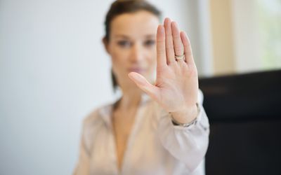 女商人展示她的结婚戒指与停止的手势