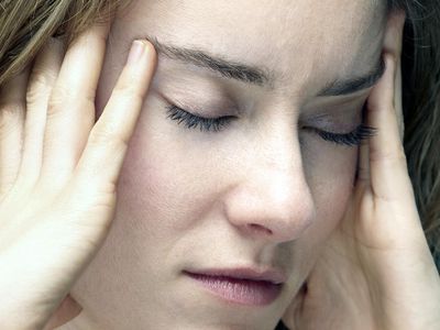 young woman with headache and holding her temples