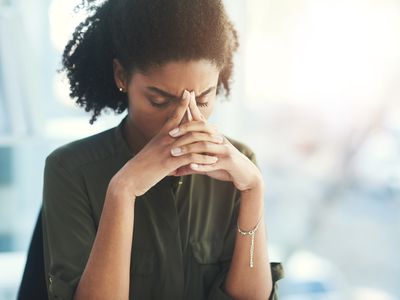 一位年轻女商人在办公室里看起来压力过大的照片